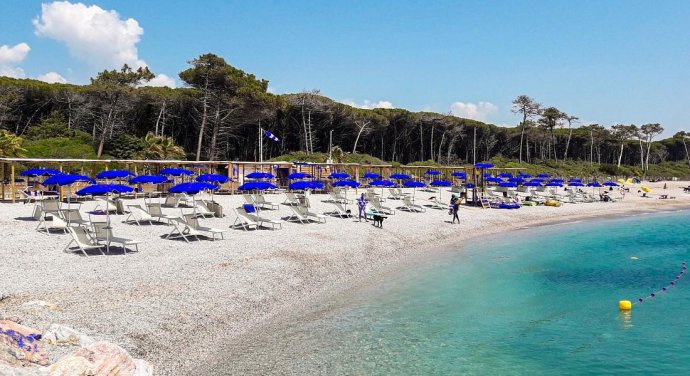 Le Gorette a Marina di Cecina con ombrelloni, ghiaia e pineta del Tombolo sullo sfondo