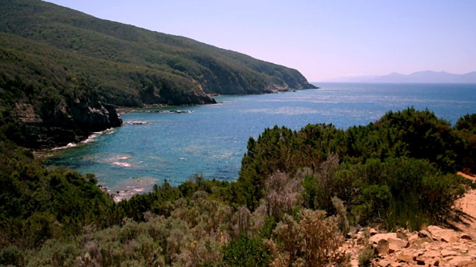 Baia rocciosa Buca delle Fate con mare turchese e macchia mediterranea vista dal sentiero