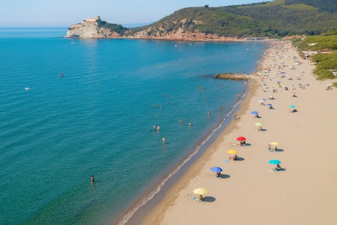 Spiaggia Levante a Castiglione della Pescaia, mare turchese, ombrelloni colorati.