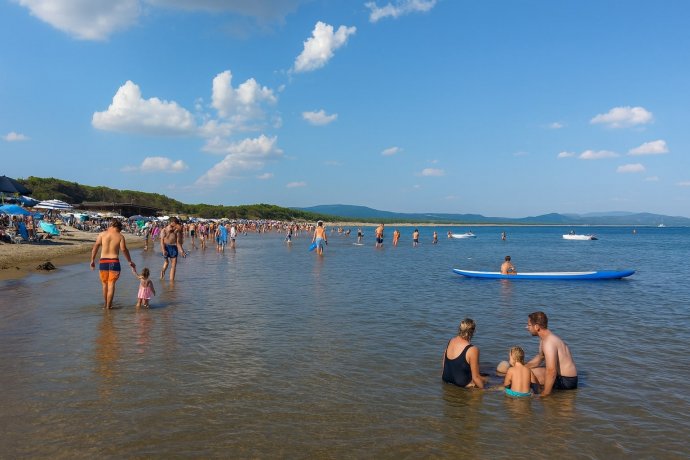 Feniglia, Toscana: famiglia in acqua, bagnanti e tavola blu su mare calmo