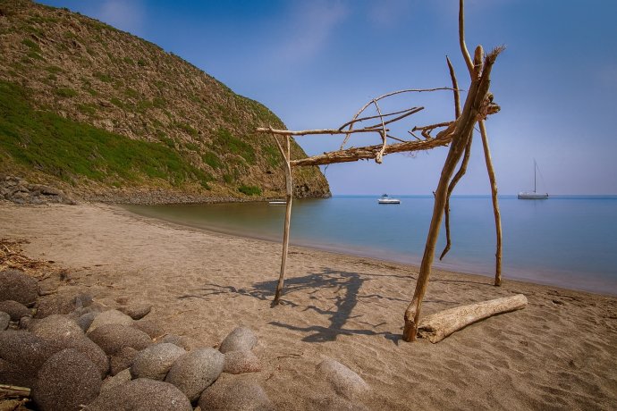 Capanna di legni sulla spiaggia sabbiosa della Cala della Mortola a Capraia, mare calmo