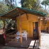 Casa di legno con veranda e sedie di plastica all'esterno.