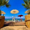 Palmette e ombrelloni su una spiaggia tropicale.
