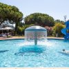 Una piscina con giochi acquatici e una fontana centrale.