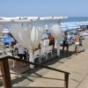 Spiaggia con gazebo, sedie e lettini.