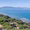 Vista costiera con mare e colline, vegetazione lussureggiante.