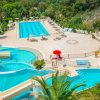 Complesso piscine con lettini e ombrelloni.