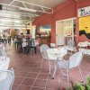 Ristorante pizzeria con tavolini e sedie su terrazza coperta.